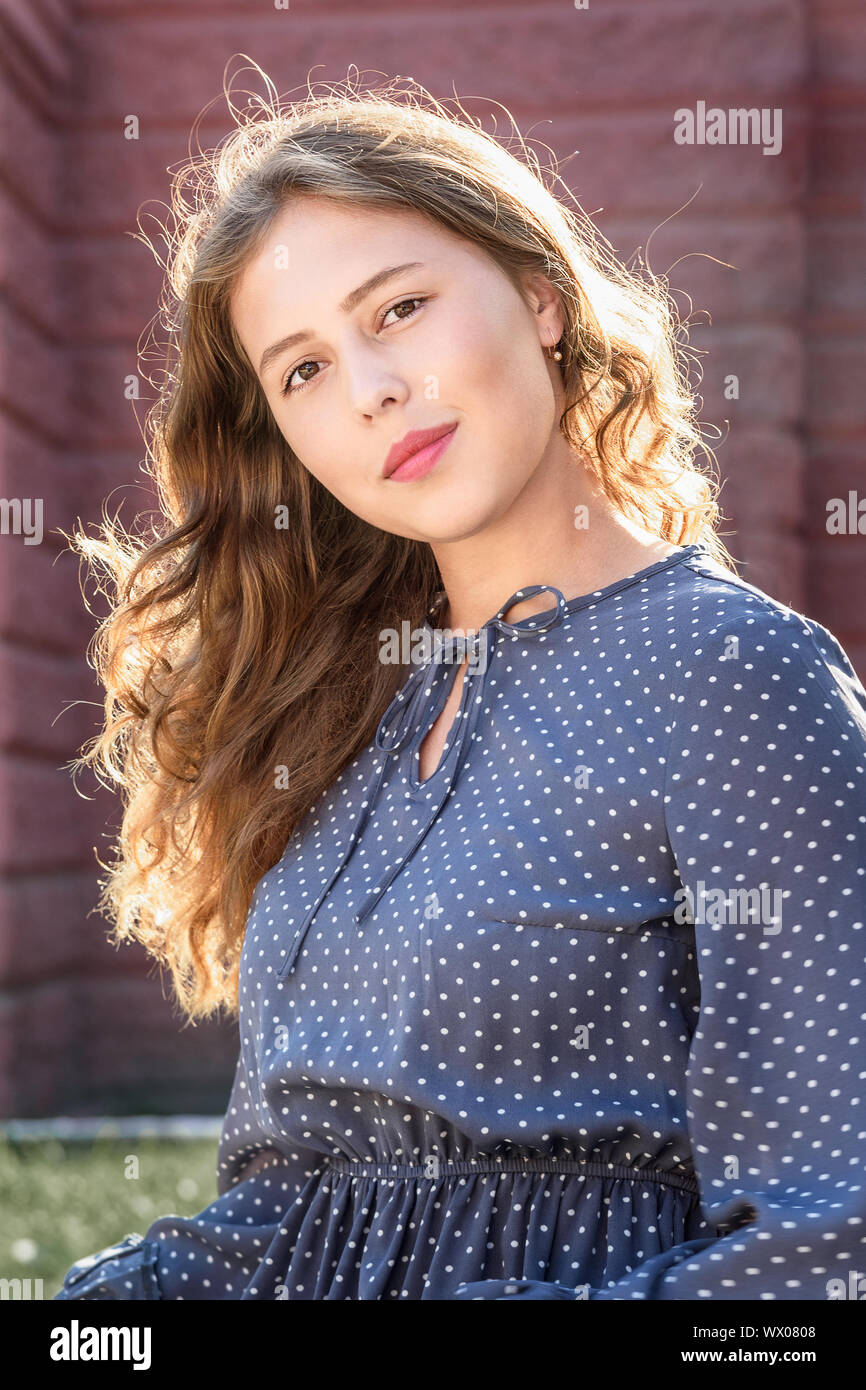 Brunette girl in the city. Portrait of girl in blue dress with long ...
