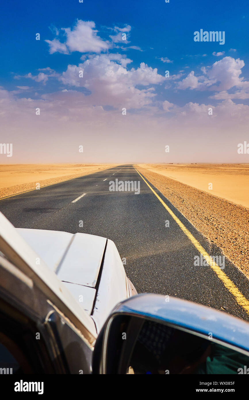 Straight as a die, grey asphalt road through the sahara Stock Photo