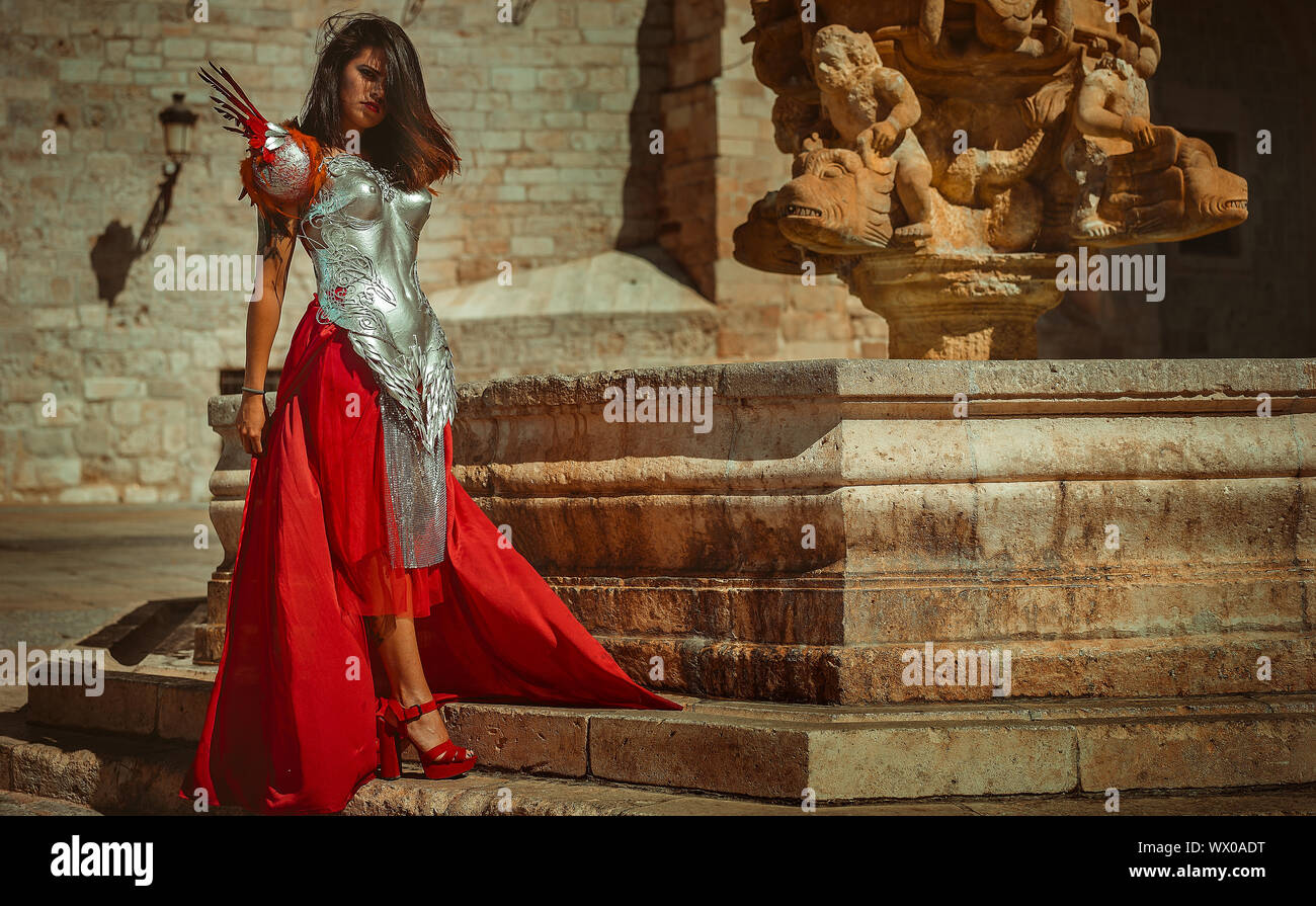 Medieval, Beautiful brunette woman wearing gold and copper corset in goddess and warrior poses. fantasy and imagination concept Stock Photo