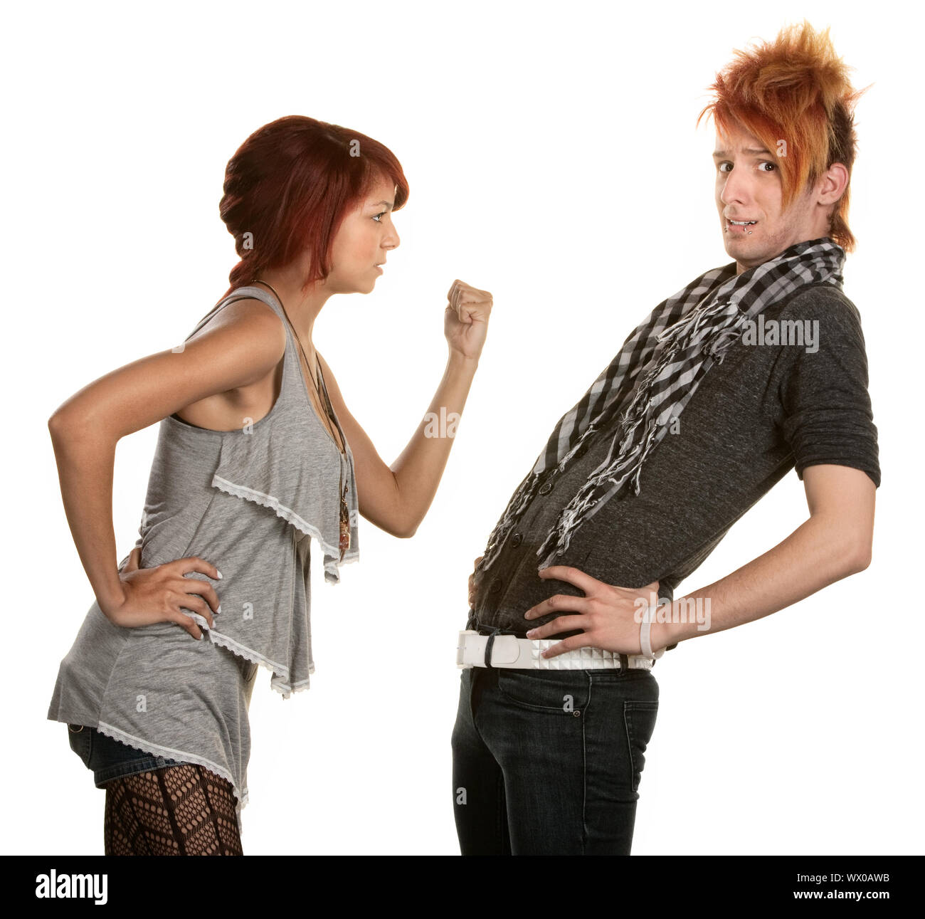 Woman shakes a clenched fist at boyfriend in orange hair Stock Photo