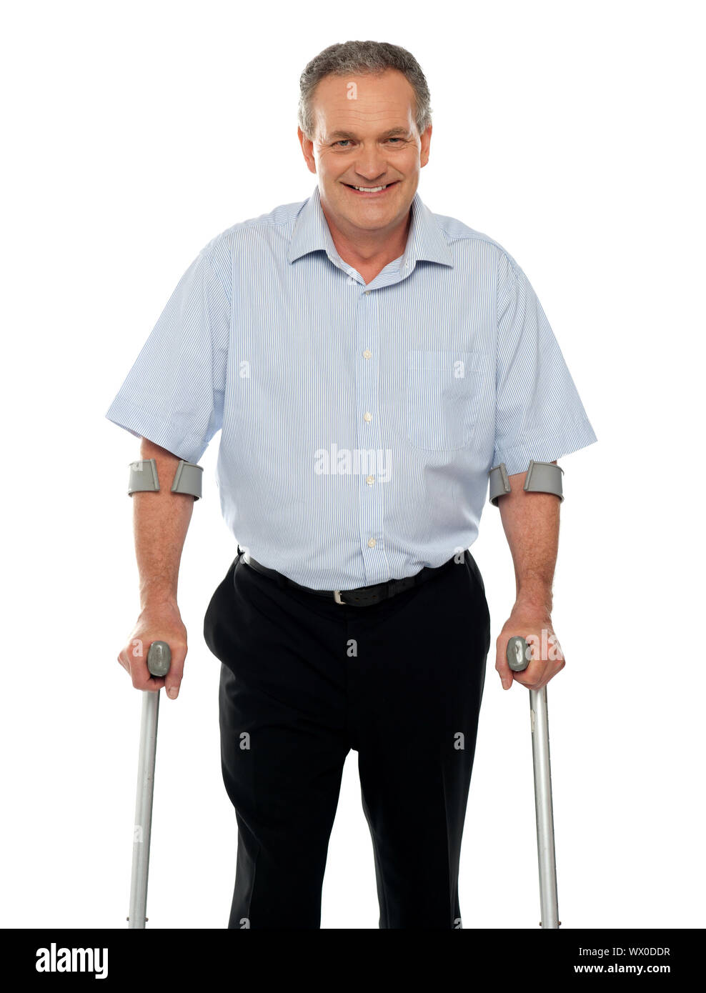 Senior man standing with support of crutches isolated against white
