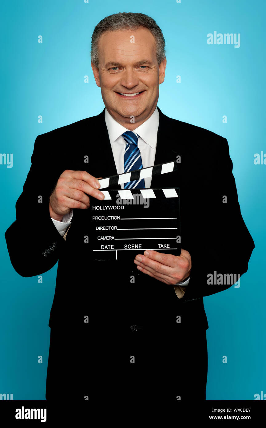Its showtime. Businessman holding clapperboard Stock Photo