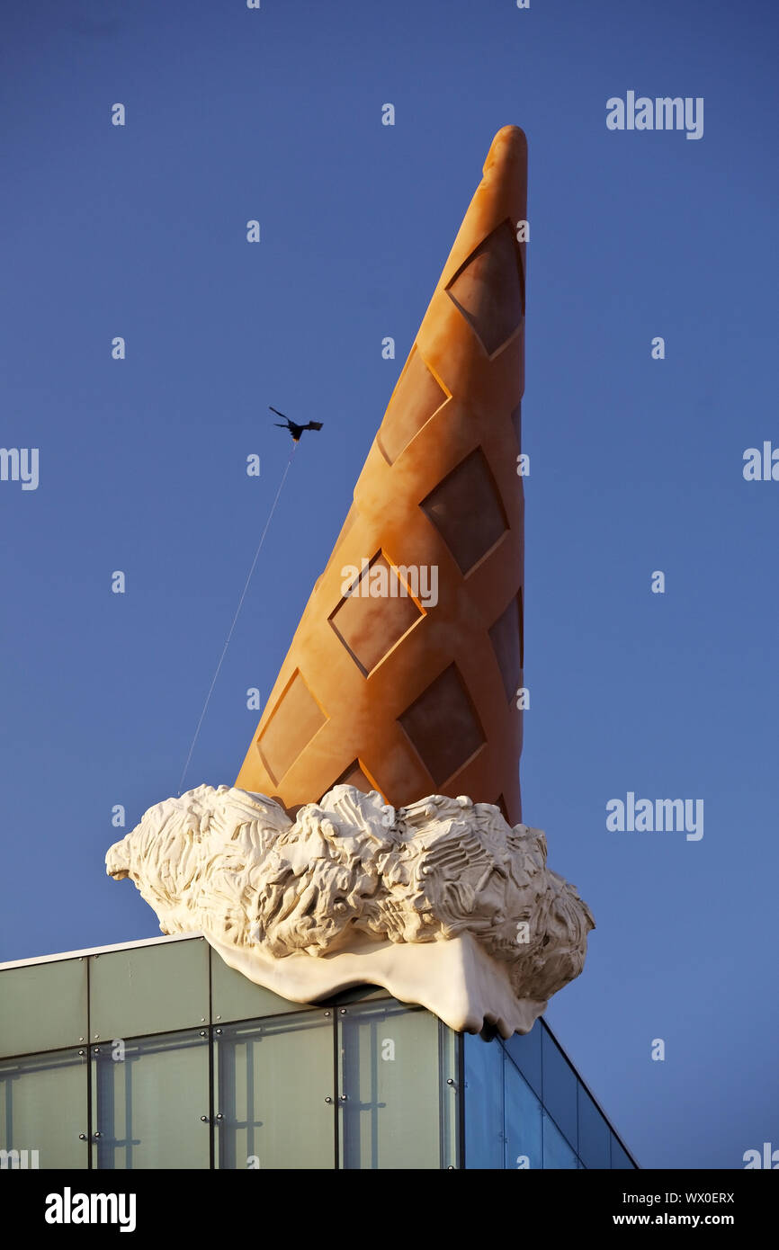 sculpture of an ice cream cone on the roof of shopping center