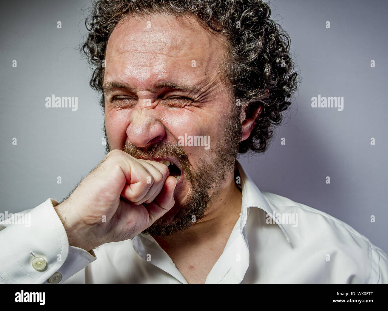 derision, man with intense expression, white shirt Stock Photo