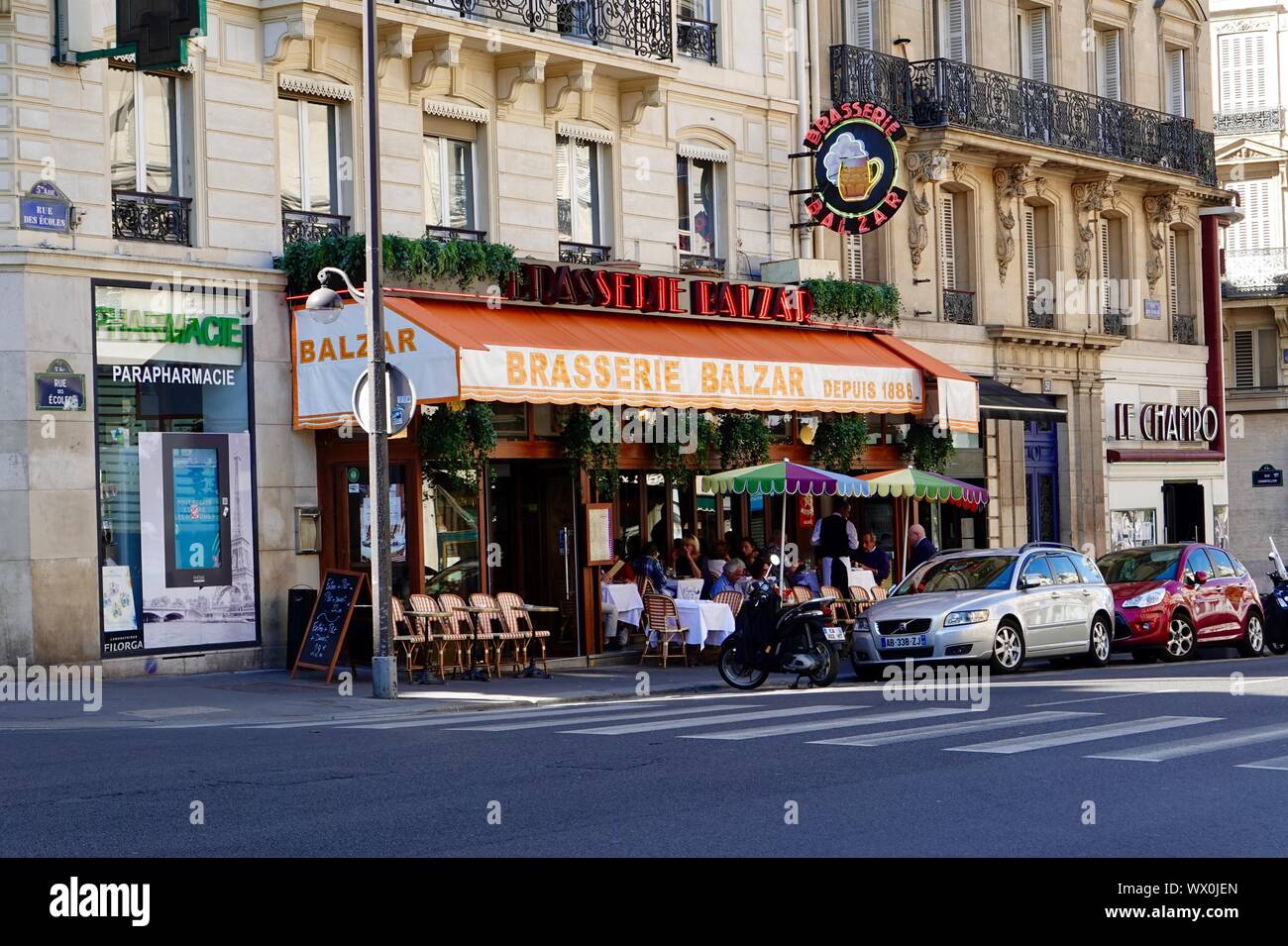 People eating outside on the sidewalk terrace of Brasserie Balzar, historic restaurant on rue des Écoles, Paris, France Stock Photo