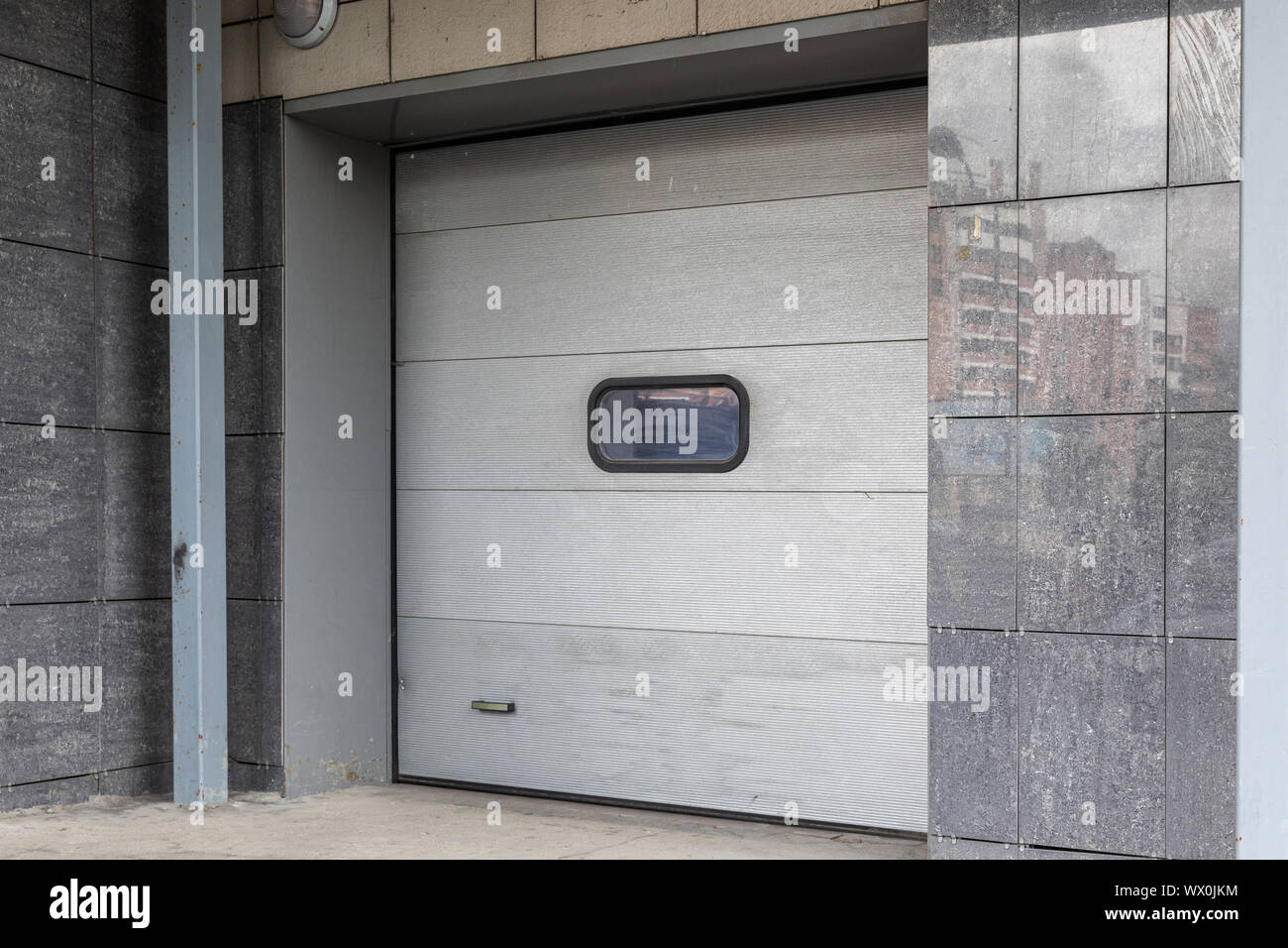 Diagonal view of gate in tiled wall with white panel door Stock Photo ...