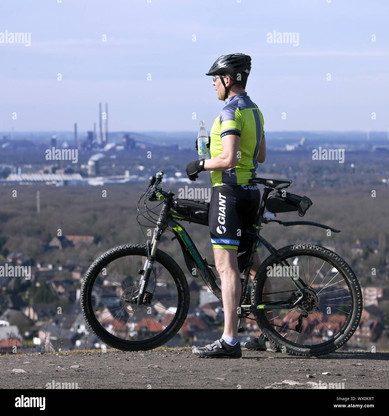 one man with his mountain bike on the summit of the Halde Haniel, Bottrop, Germany, Europe Stock Photo