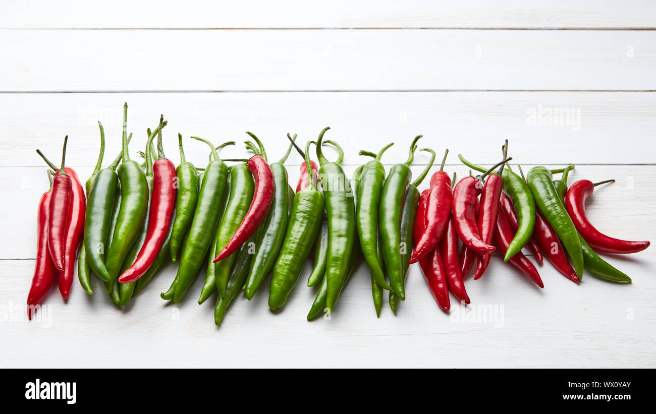 a colorful mix of the freshest and hottest chili peppers on wooden table Stock Photo