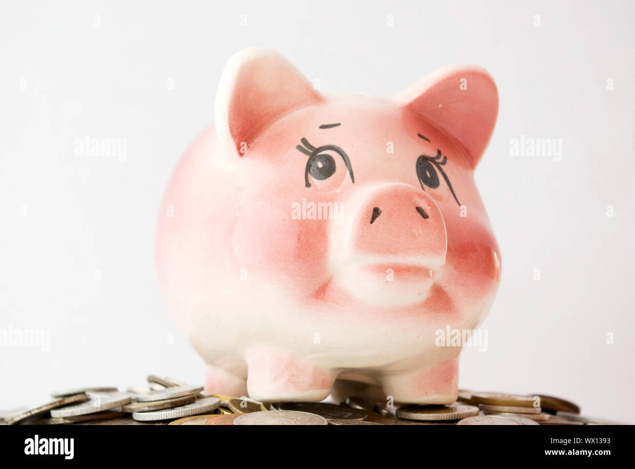 Pink piggy bank isolated on white background with coins Stock Photo - Alamy