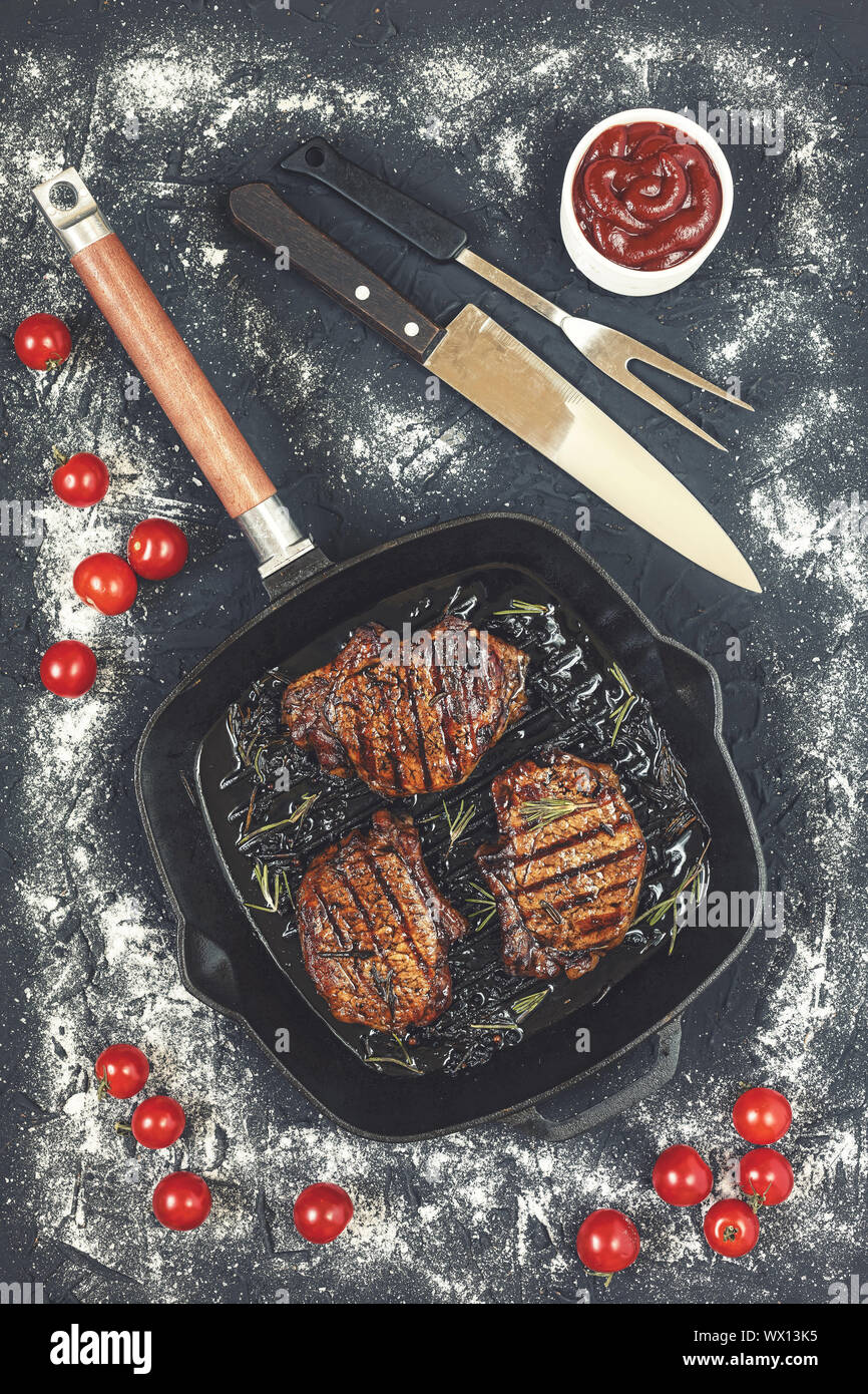 Steaks grilled, Grilled, steak, beef, balsamic, rosemary, stone table, cherry tomatoes, ketchup, top Stock Photo