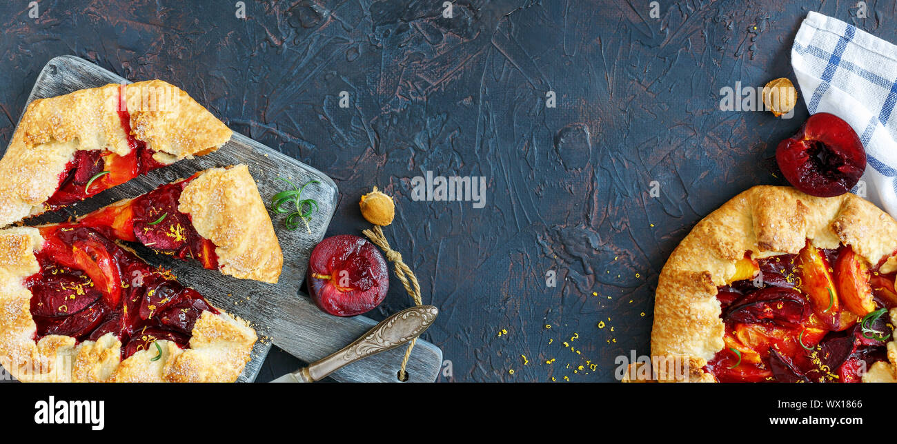 Summer pies with red and yellow plums on the serving board. Stock Photo