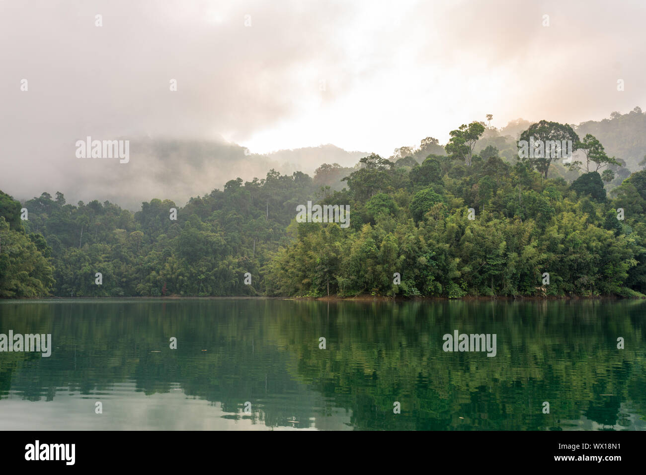 Misty mountains early morning on the Cheow Lan Lake in the national park Khao Sok in Thailand Stock Photo