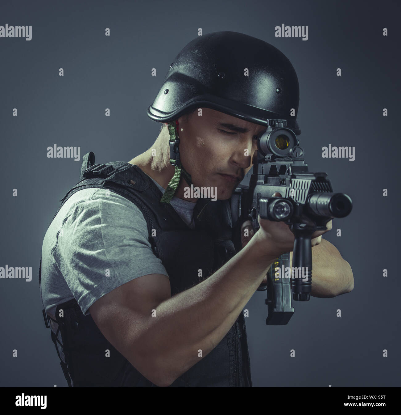 Targeting, paintball sport player wearing protective helmet aiming