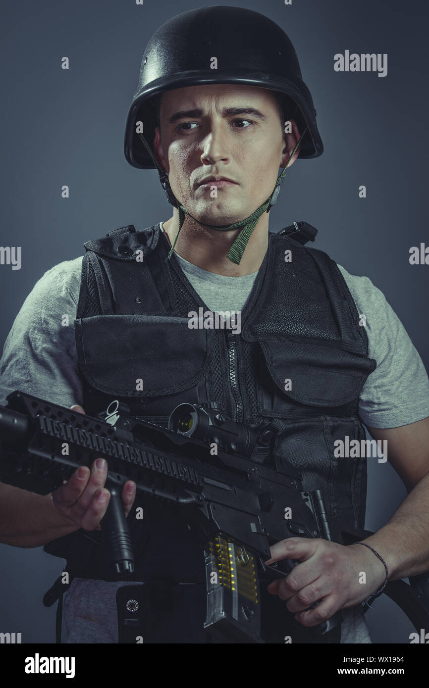 paintball sport player wearing protective helmet aiming pistol ,black