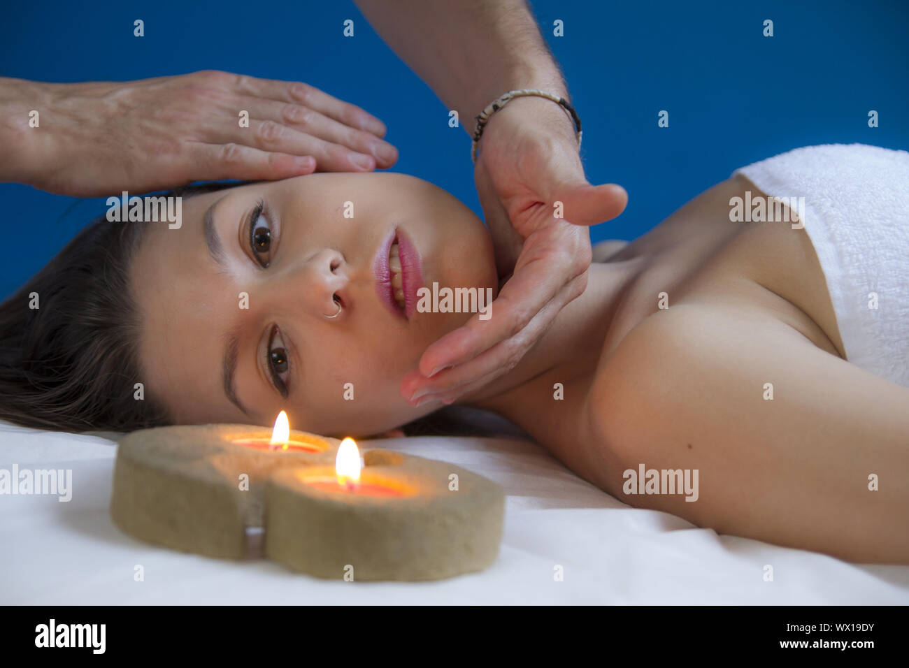 spa, attractive brunette spanish girl getting a massage on her face and neck by a massage professional Stock Photo