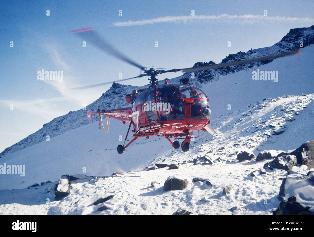A red rescue helicopter departs from the Tete Rousse hut for a high altitude rescue, Chamonix, France. Stock Photo
