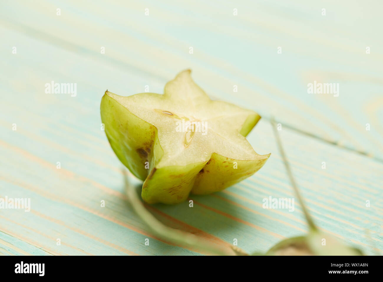 half fresh green carambola on a wooden background Stock Photo