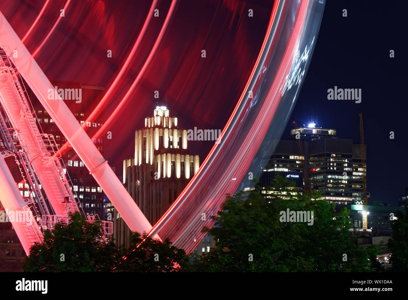 La Grande Roue in Montreal at night with the Aldred Building beyond Stock Photo