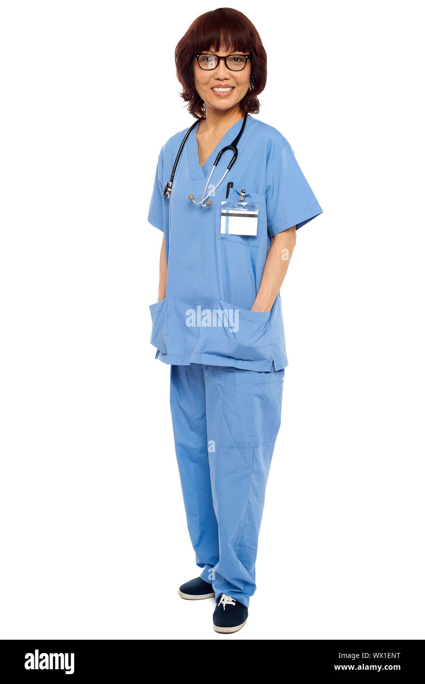Asian surgeon posing with hands in her coat pocket isolated against white Stock Photo