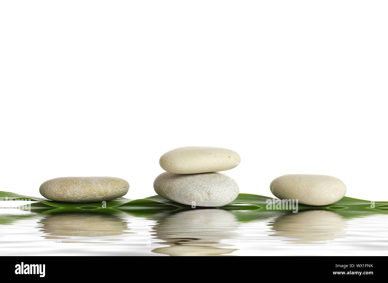 Spa stones and green leaf, isolated on white background Stock Photo - Alamy