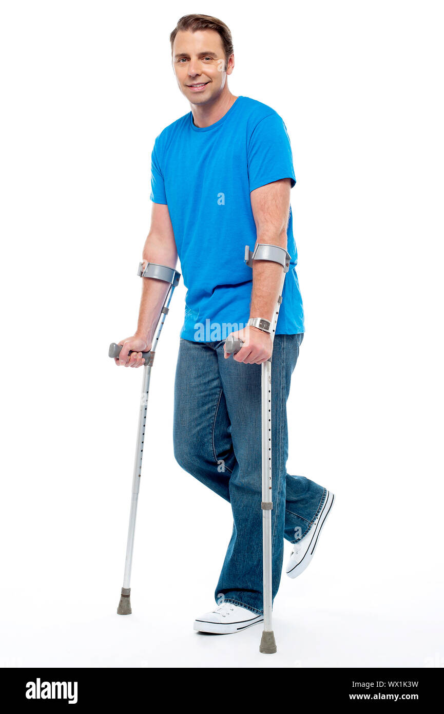 Young man with crutches trying to walk. Accidental case Stock Photo