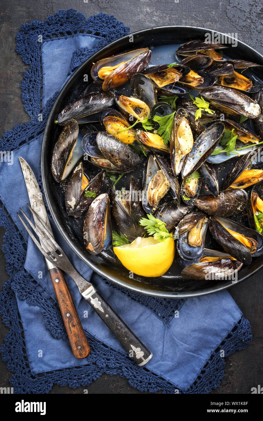 Traditional barbecue Italian blue mussel in white wine as top view in a casserole Stock Photo