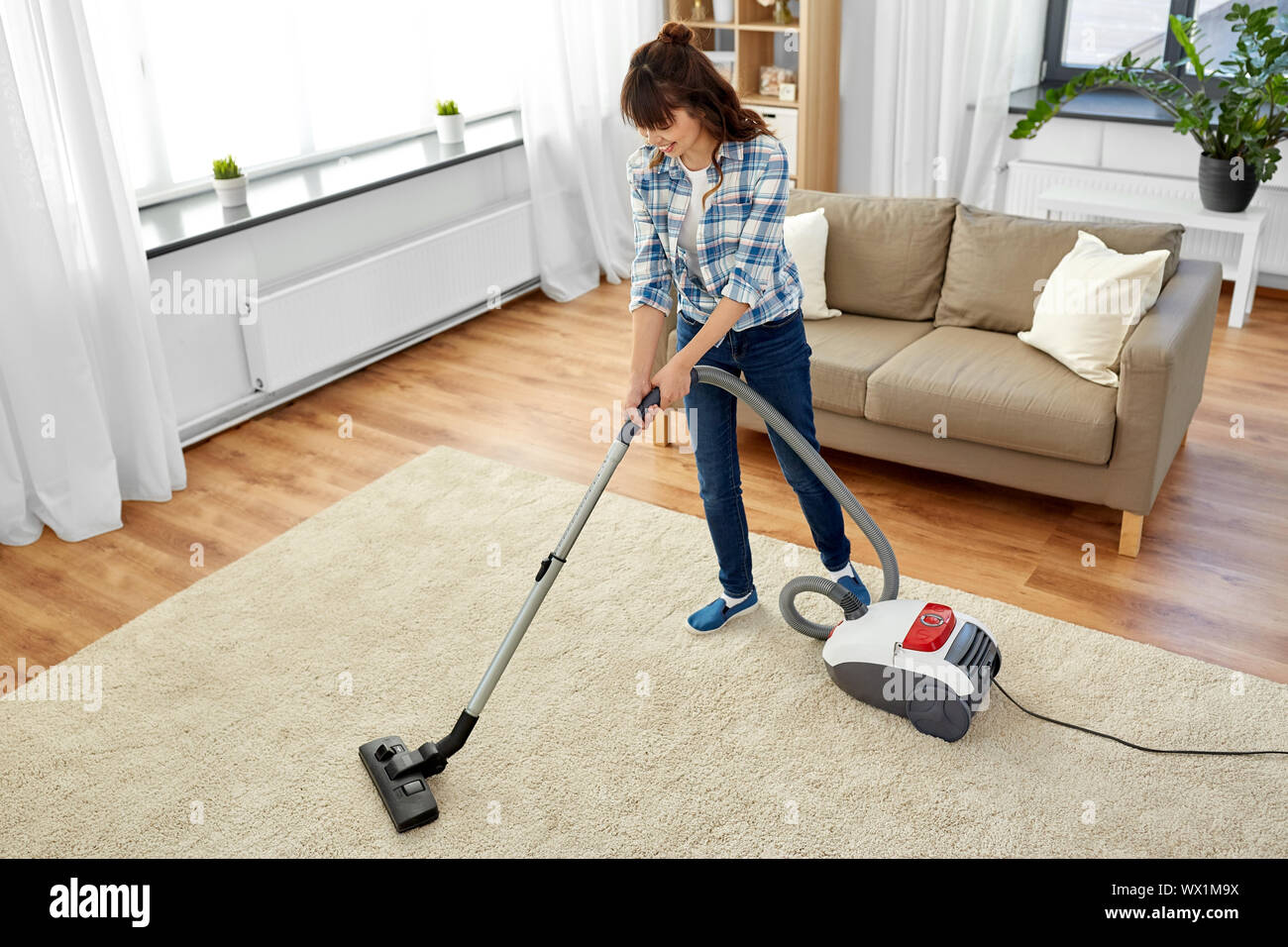 asian woman with vacuum cleaner at home Stock Photo