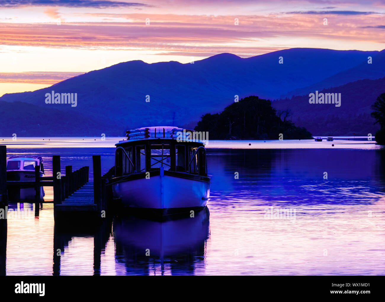 A boat moored at Bowness on Windermere at sunset, Lake District, UK Stock Photo