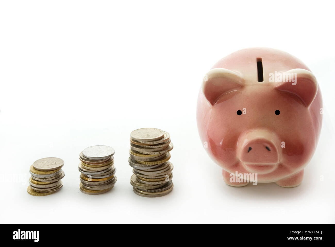 Pink piggy bank isolated on white background with coins Stock Photo - Alamy