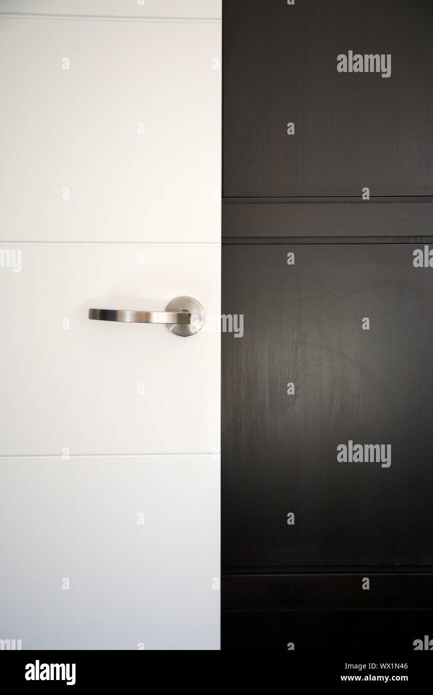 White Modern Door With Handle On Black Wardrobe Stock Photo
