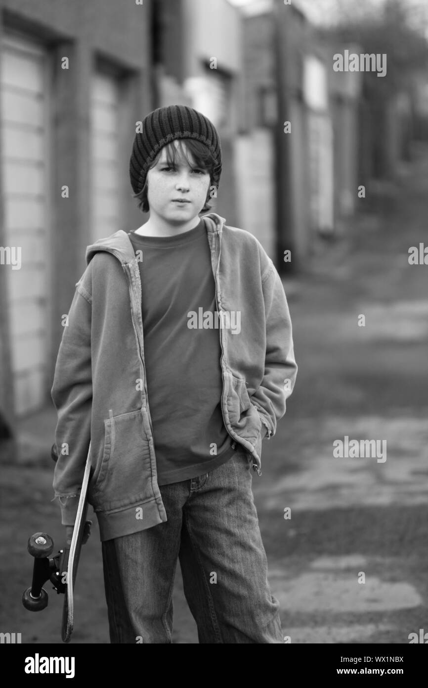 Moody skateboarder in an alleyway, black and white Stock Photo