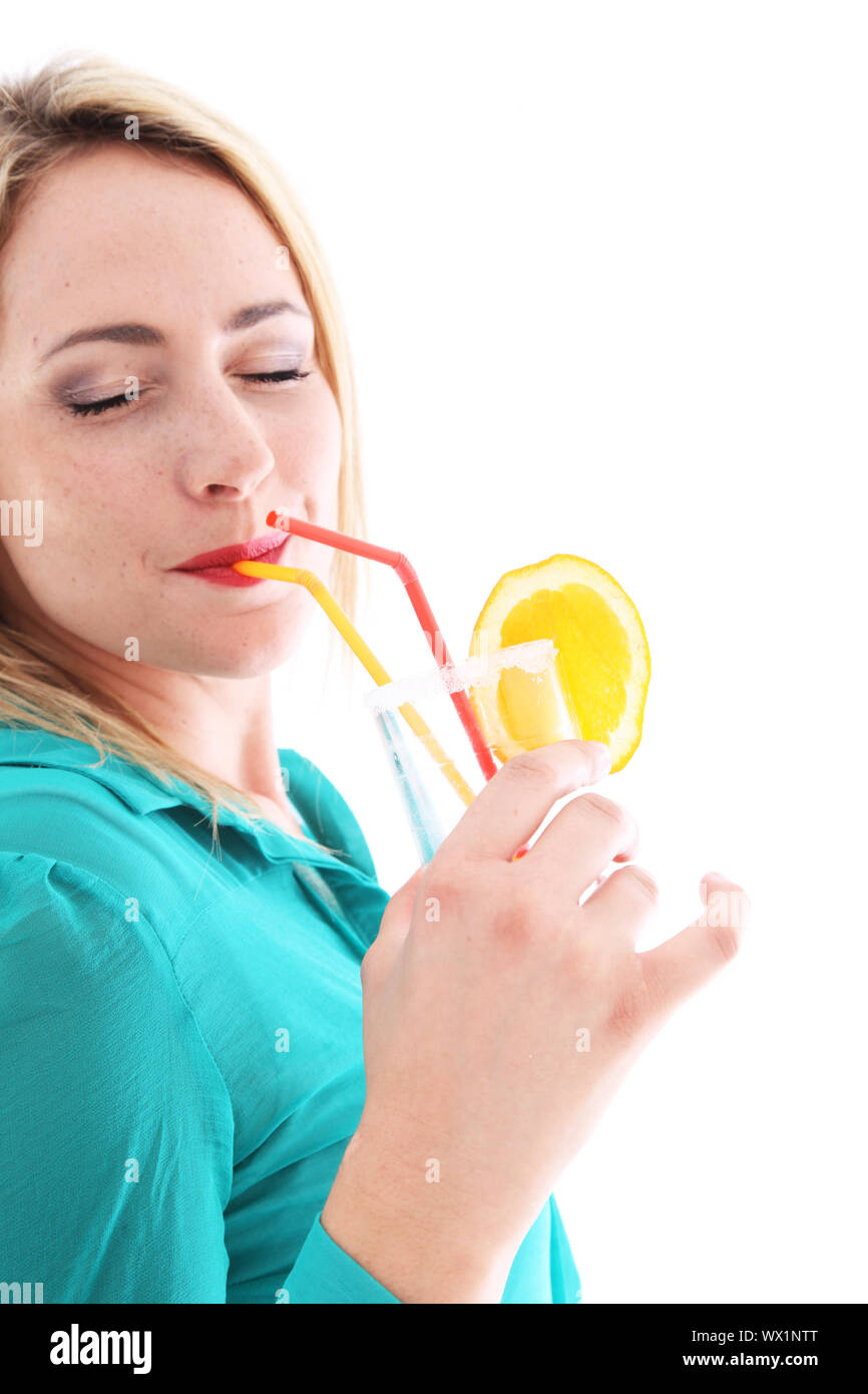 Blissful woman in a turquoise top drinking orange cocktail with her eyes closed as she savours every last drop on her summer vacation Stock Photo