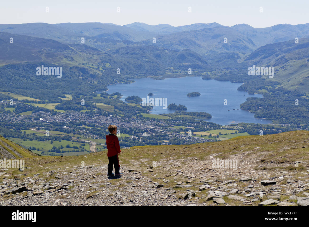 A young boy(7 yrs old) high on Skiddaw in the Lake District with Keswick and Derwent Water below Stock Photo