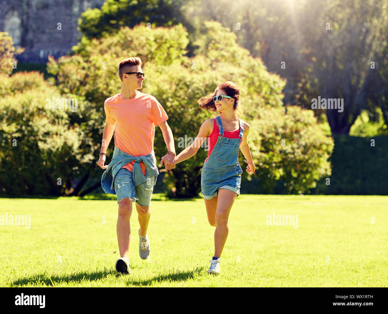happy teenage couple running at summer park Stock Photo