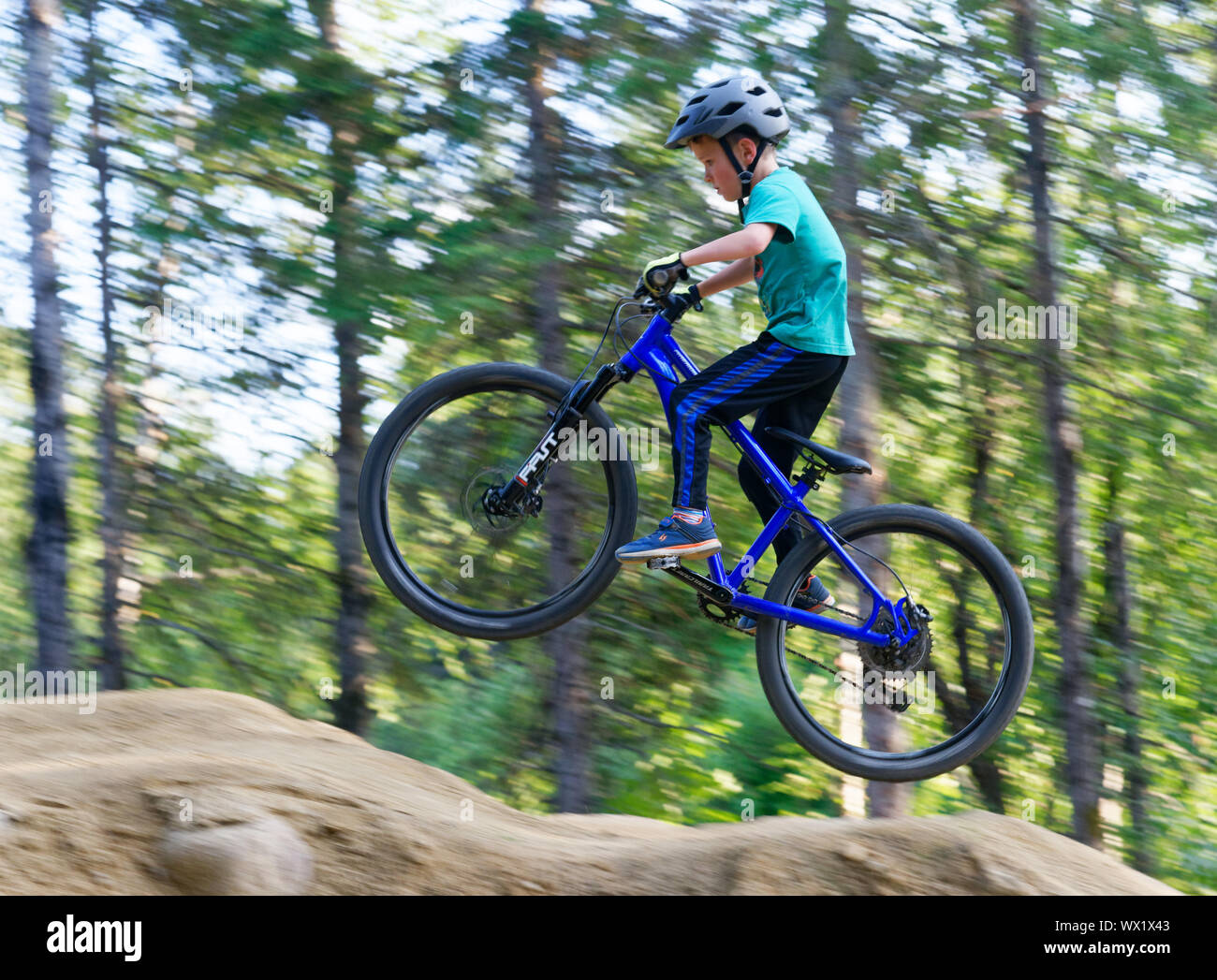 A seven year old boy doing jumps on his mountain bike Stock Photo