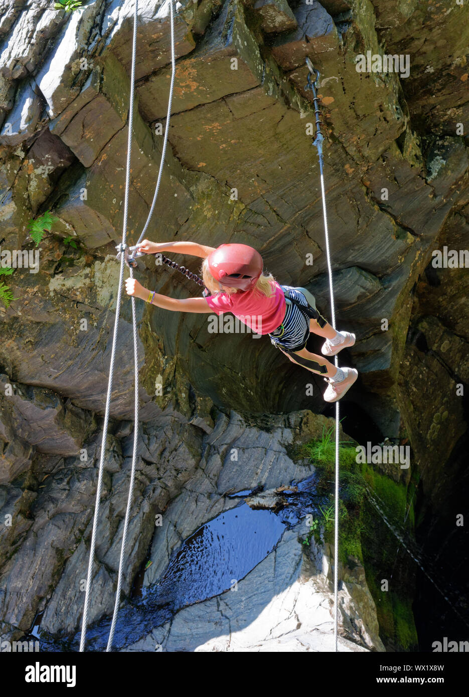 A young girl on a tightrope between cliifs on the Canyon Sainte Anne via ferrata, Quebec, Canada Stock Photo