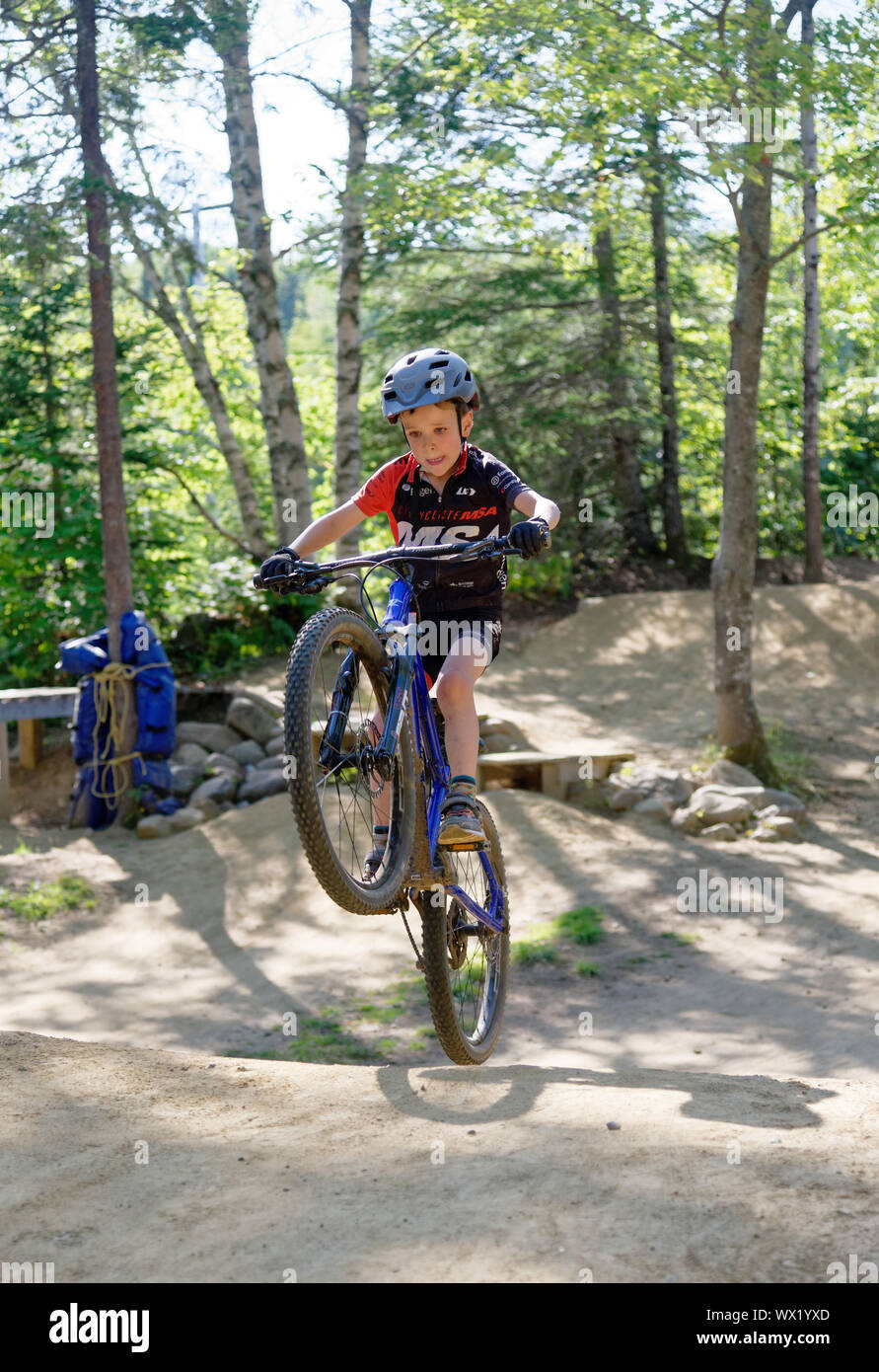 A seven year old boy popping a huge wheelie on his mountain bike Stock Photo