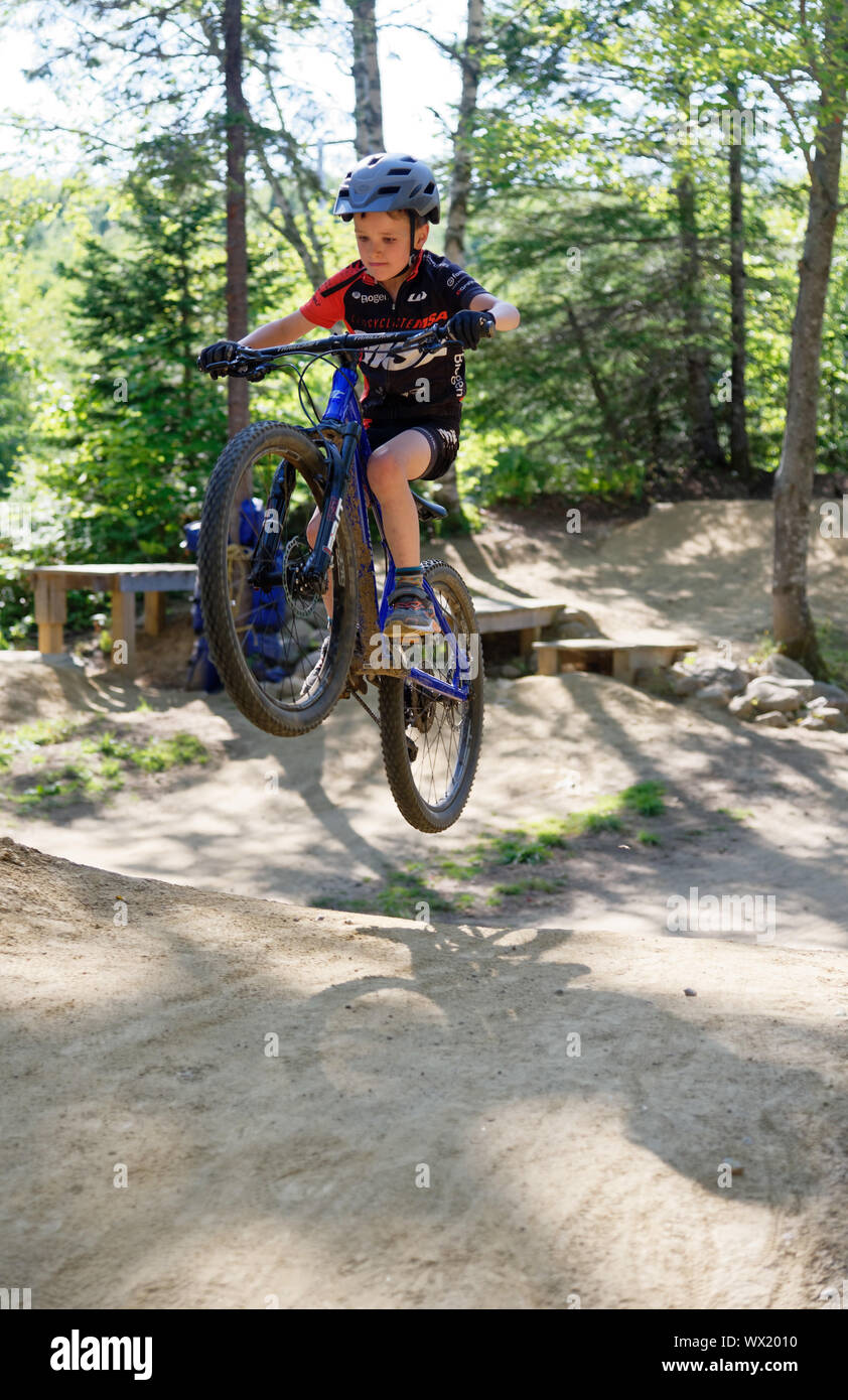 A seven year old boy doing jumps on his mountain bike Stock Photo