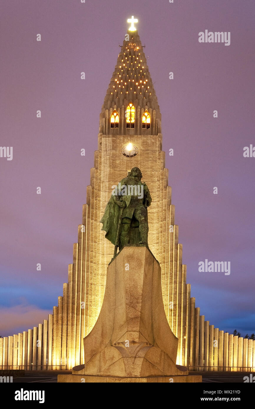 Illuminated Hallgrímskirkja with statue of Leif Eriksson at dusk, Reykjavik, Iceland, Europe Stock Photo