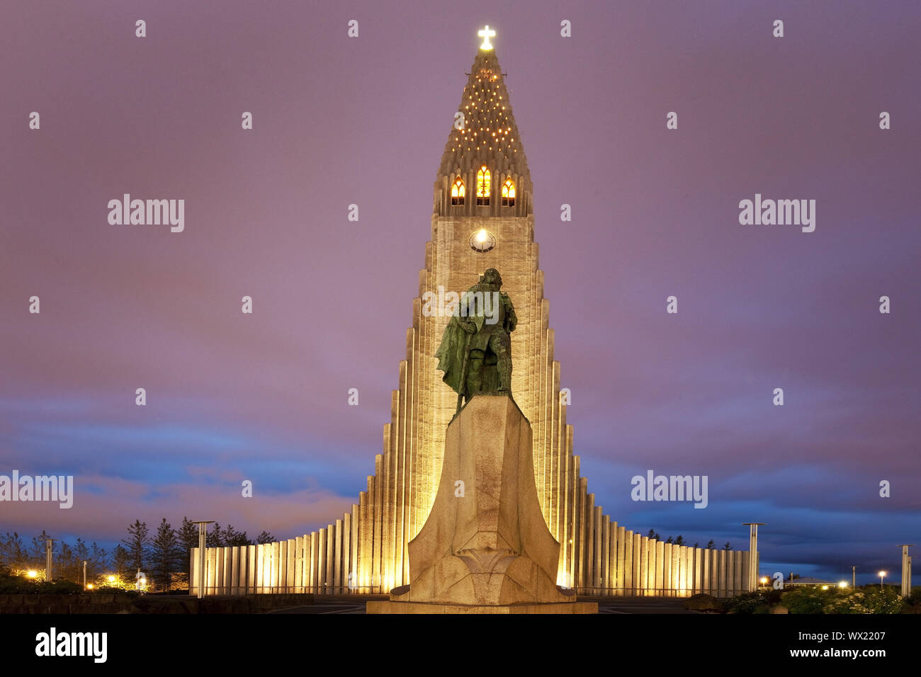 Illuminated Hallgrímskirkja with statue of Leif Eriksson at dusk, Reykjavik, Iceland, Europe Stock Photo