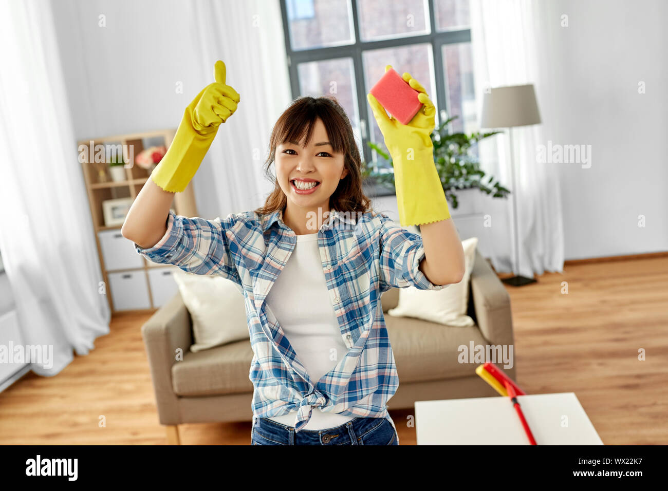 happy asian woman with sponge cleaning at home Stock Photo