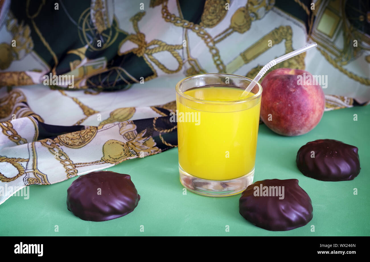 Still life: fresh orange juice, candy, Apple. Stock Photo