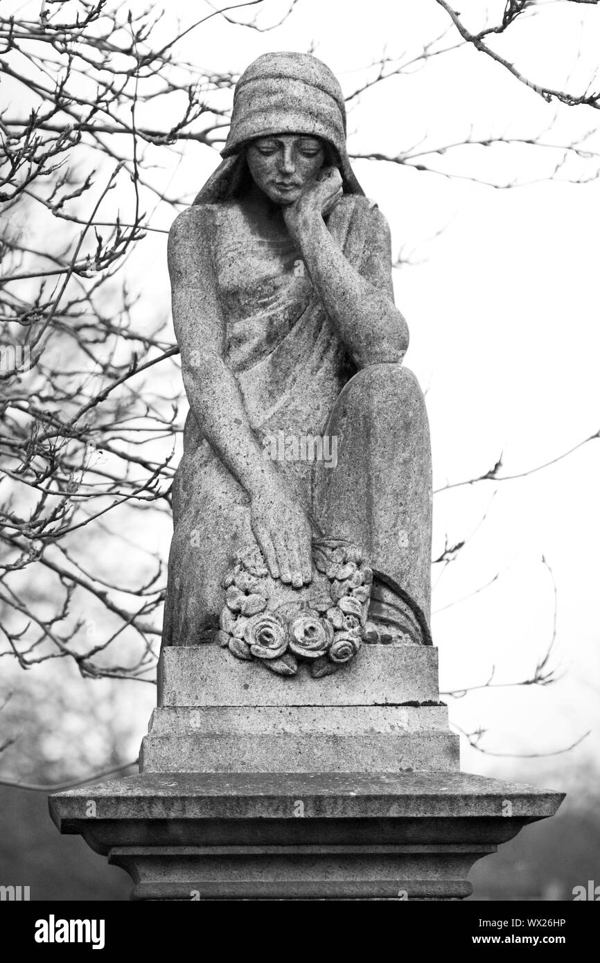 Statue adorning the top of a gravestone Stock Photo