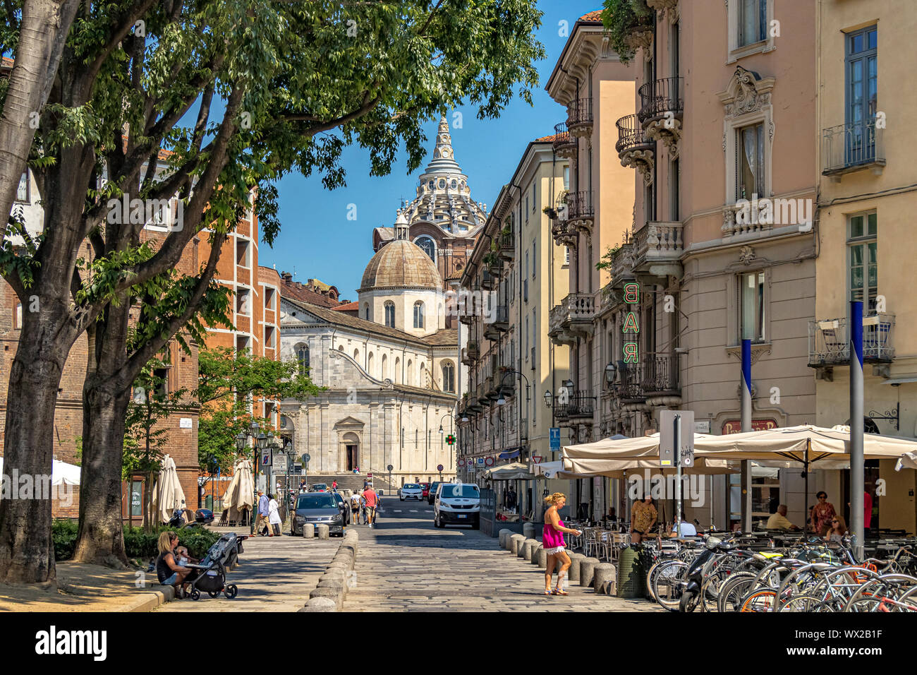 A view along the cobbled street of Largo IV Marzo , with the dome of the  Baroque chapel Cappella della Sacra Sindone in the distance ,Turin ,Italy Stock Photo