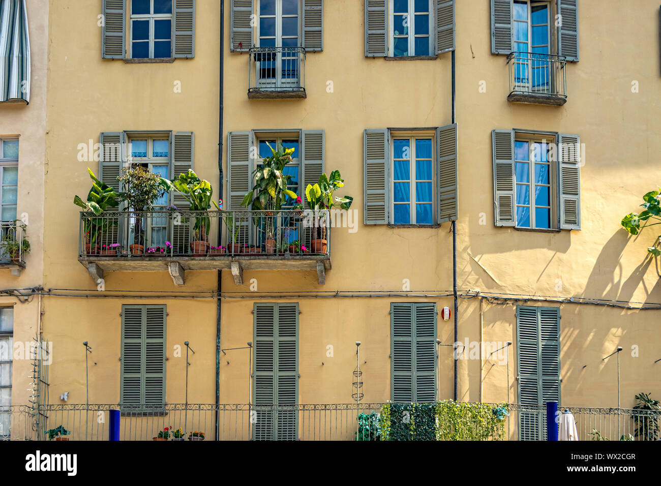 Italian apartment building with window boxes with flowers and windows with  hutters on a building along Largo IV Marzo in Turin ,Italy Stock Photo