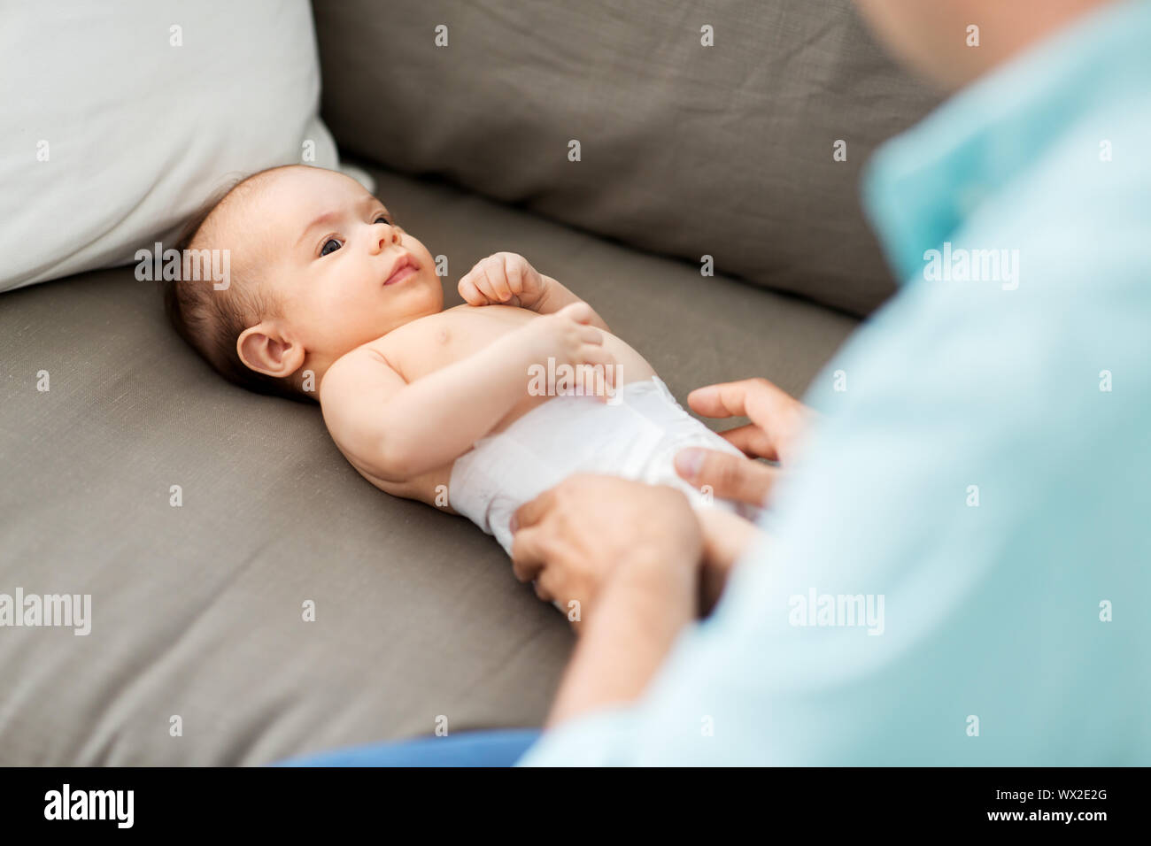 middle aged father changing baby's diaper at home Stock Photo Alamy