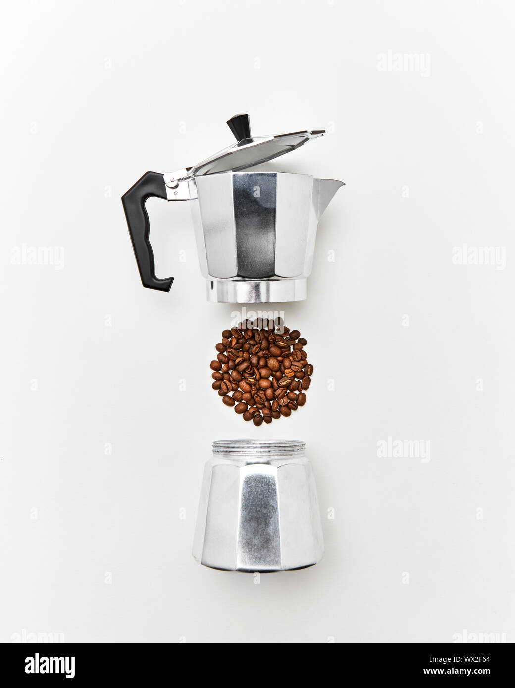 Metal coffee maker and a pattern of coffee beans in the shape of a circle on a gray background with copy space for text. Making Stock Photo