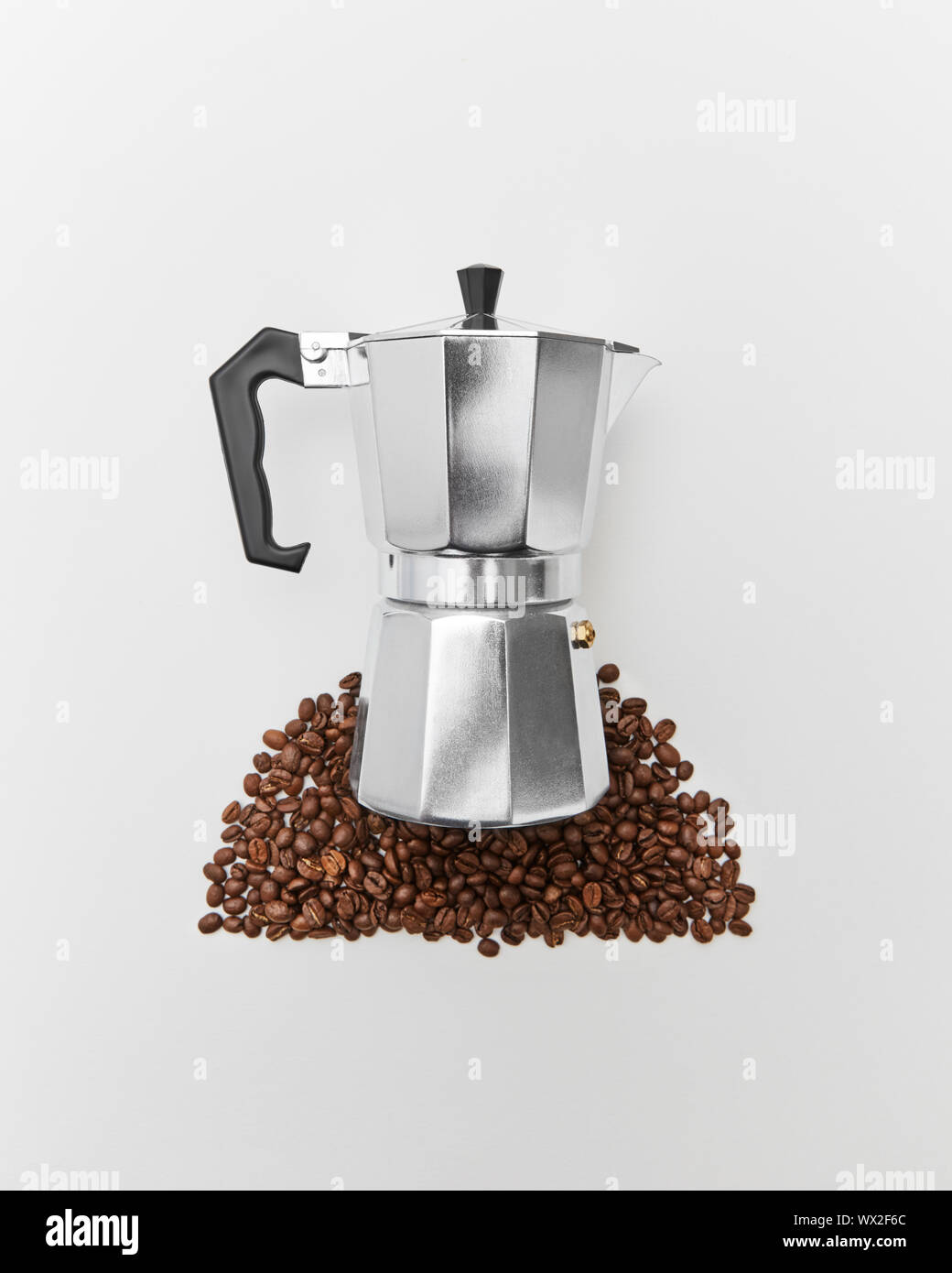The pattern of coffee beans and a metal coffee maker on a gray background with space for text. Concept of morning coffee. Flat l Stock Photo