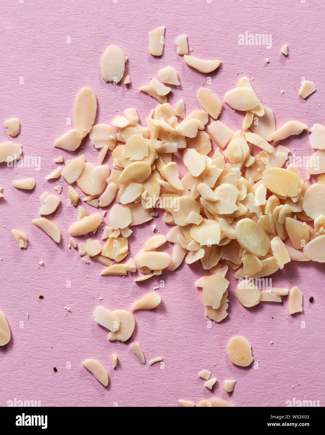 Slices of almond in the heap on a pink background. Close-up view Stock Photo