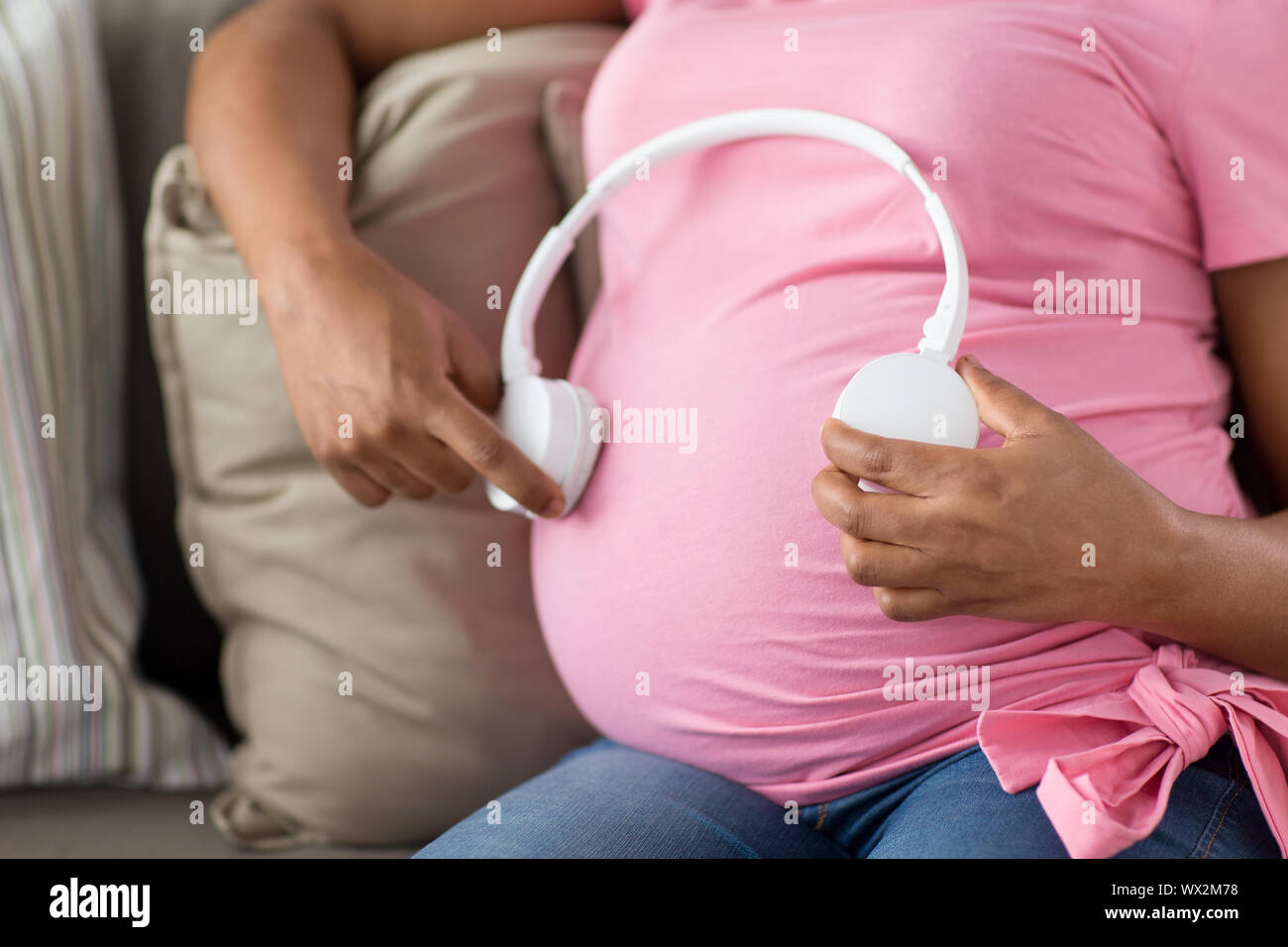 pregnant woman with headphones on her belly Stock Photo Alamy